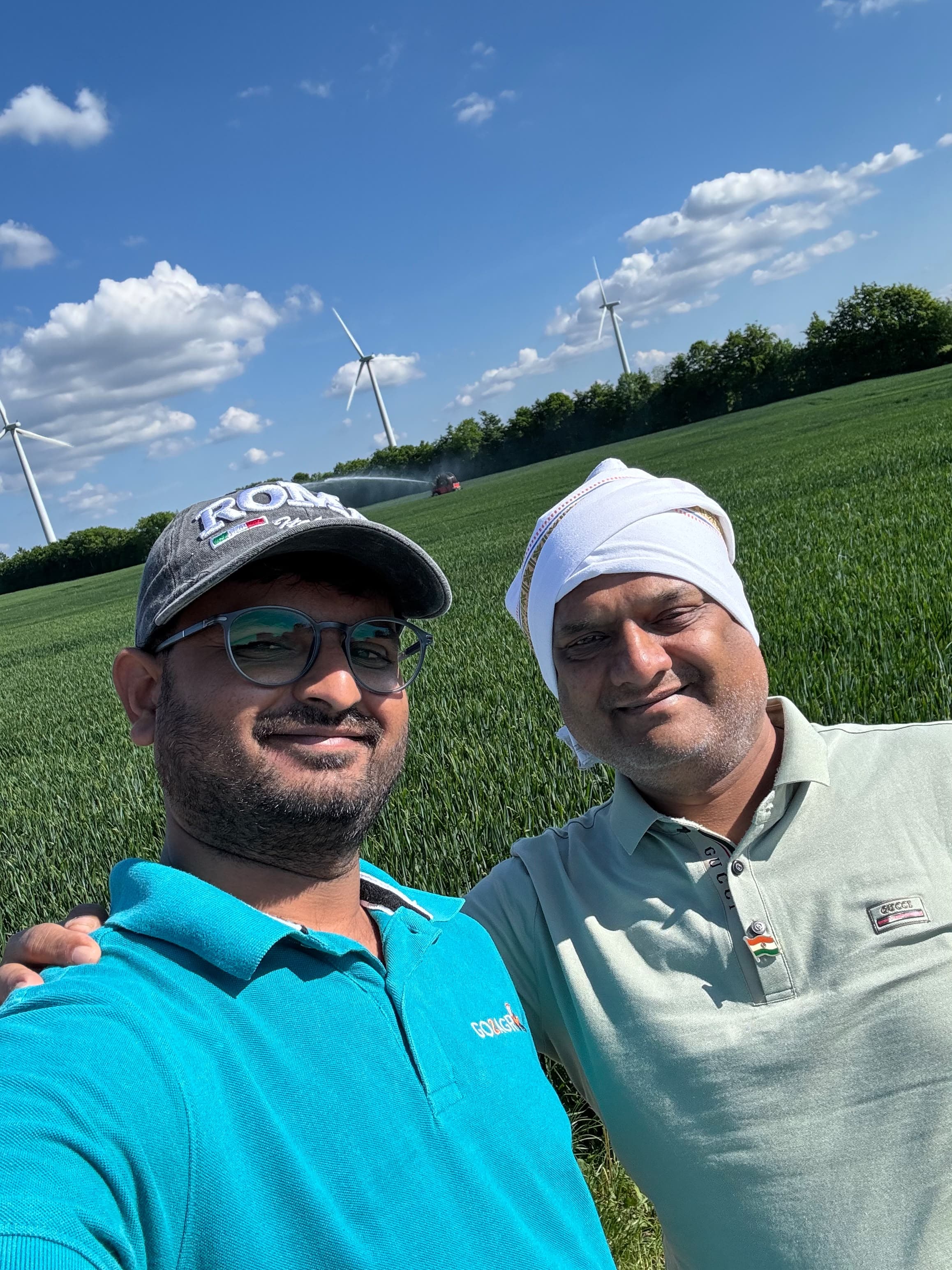 Students working on an international farm — farm-field-partners-wind-turbines